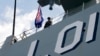 FILE - An Australian Navy crew member stands on the deck of the Royal Australian Navy HMAS Adelaide, Oct. 10, 2017, in Manila, Philippines. 