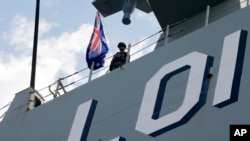 FILE - An Australian Navy crew member stands on the deck of the Royal Australian Navy HMAS Adelaide, Oct. 10, 2017, in Manila, Philippines. 