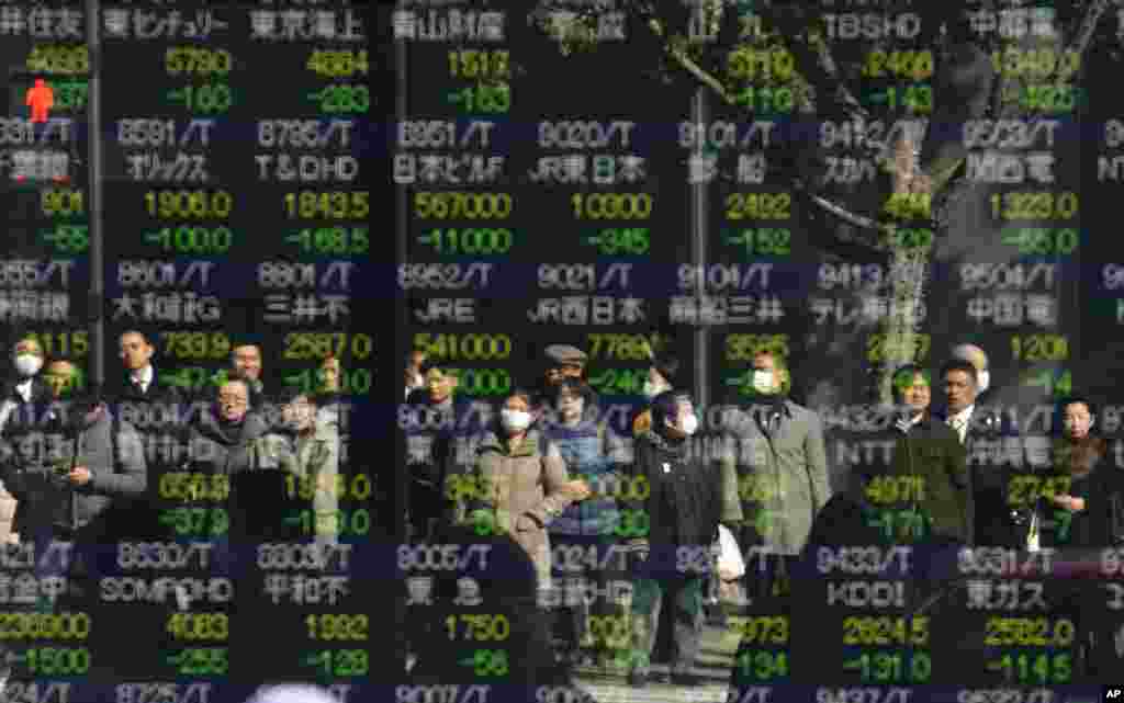 People are reflected on an electronic stock indicator of a securities firm in Tokyo, Japan.