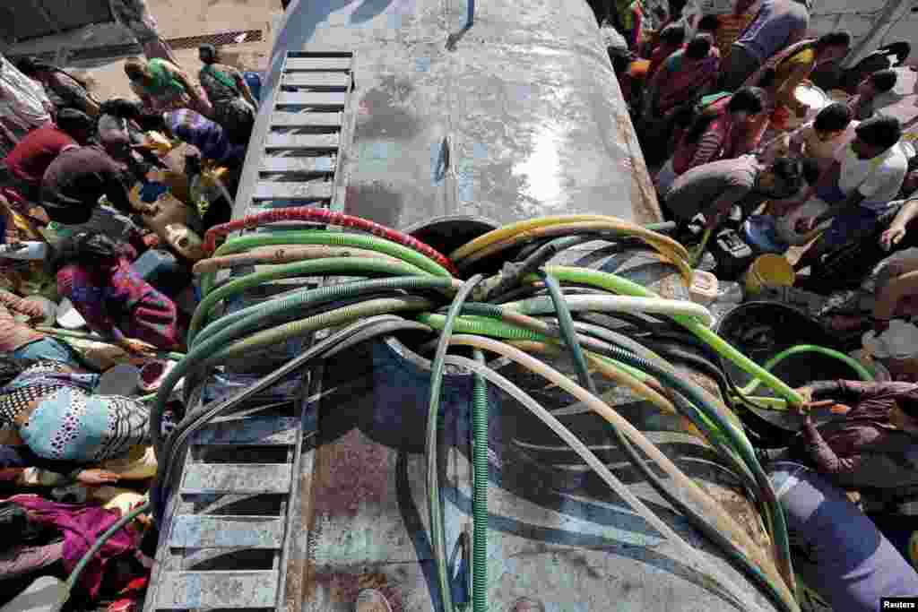 Residents with their empty containers crowd around a municipal tanker to fetch water in New Delhi, India. The Indian army has taken control of a canal that supplies three-fifths of Delhi's water, the state's chief minister said, raising hope that a water crisis in the metropolis of more than 20 million people can be averted.