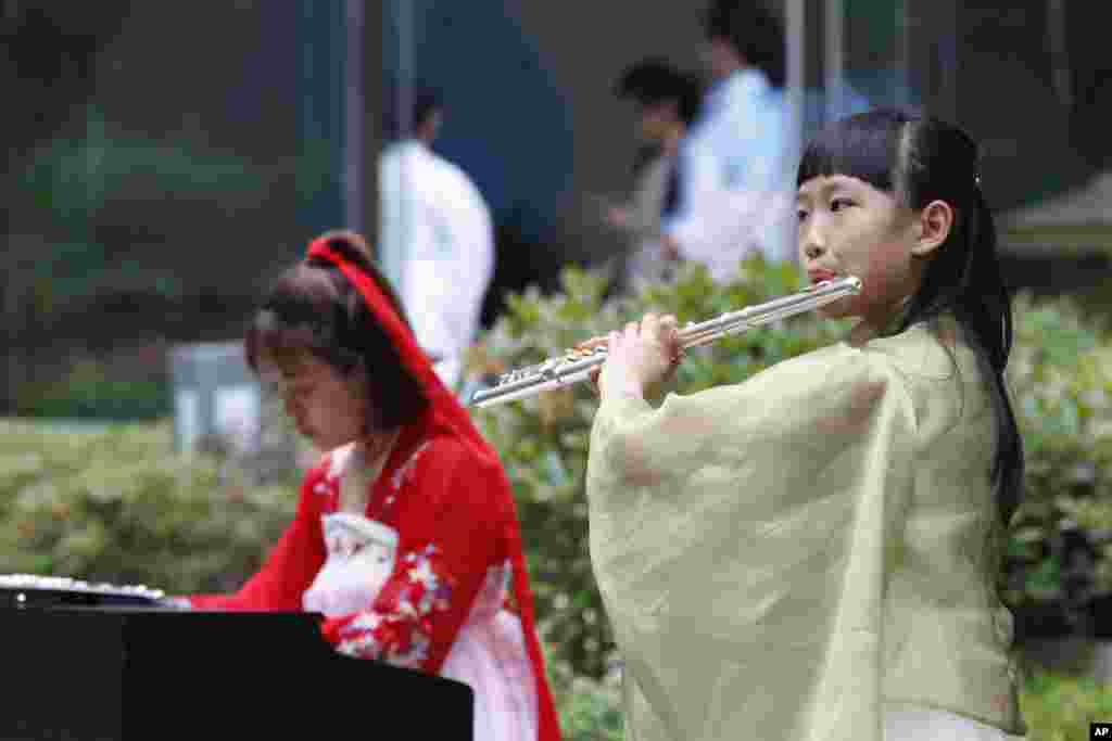 2018年6月9日，青岛的上海合作组织（SCO）峰会媒体中心，音乐人演奏古筝和长笛。此次上合组织青岛峰会在官媒渲染下盛况空前，中国为与会国代表举行了欢迎宴会，还有文艺演出和焰火表演。有一些推特用户以此和同一时段举行的工业7国峰会做比较，赞扬G7峰会之简朴，批评青岛峰会之奢华。有人说：&ldquo;西方富国开穷会，东方穷国开富会。&rdquo;