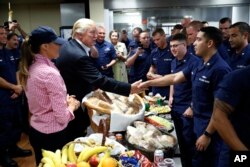 President Donald Trump, with first lady Melania Trump, greets and hands out sandwiches to members of the U.S. Coast Guard, at the Lake Worth Inlet Station, on Thanksgiving, Nov. 23, 2017, in Riviera Beach, Florida.