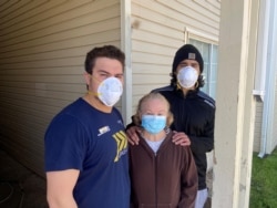Anthony, 22; Pilar, 53; and Michael Jimenez, 26, have all tested positive for COVID-19. Here, they stand beside their Guymon, Okla., home May 14, 2020, six days after their father and husband, Felix Jimenez, died after testing positive for the virus.