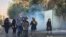 In this Oct. 1, 2022, photo taken by an individual not employed by the Associated Press and obtained by the AP outside Iran, tear gas is fired to disperse protestors in front of the Tehran University, Iran.