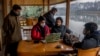 FILE- Fahad Shah, center sitting, editor-in-chief of The Kashmir Walla, and other Kashmiri Journalists prepare for a meeting to discuss the shutting of Kashmir Press Club building, the region's only independent press club, in Srinagar, Indian-controlled Kashmir, Jan. 20, 2022.