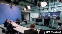 Presiden Ukraina Volodymyr Zelenskiy muncul di layar saat Kanselir Jerman Olaf Scholz menghadiri pertemuan para pemimpin G7 virtual di Kanselir di Berlin, Jerman, 11 Oktober 2022. (Steffen Kugler/BPA/Handout via REUTERS)