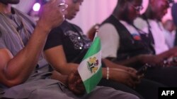 A man holds a Nigerian flag in Lagos on Oct. 20, 2022, during a commemoration of the #EndSARS protests. Nigerians were in shock two years ago after a deadly shooting of peaceful protesters in Lagos that Amnesty International blamed on security forces.