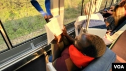 FILE - Reporter Ignatius Annor reading ''28 Barbary Lane,'' popularly known as ''Tales of the City'' by Armistead Maupin en route to Washington by train, Sept. 1, 2022.