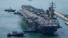 FILE - The U.S. carrier USS Ronald Reagan is escorted as it arrives in Busan, South Korea on Sept. 23, 2022. The American aircraft carrier was due to make a port call in Vietnam on June 25, 2023, a rare visit by one of the U.S. Navy's biggest ships.