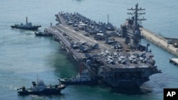 FILE - The U.S. carrier USS Ronald Reagan is escorted as it arrives in Busan, South Korea on Sept. 23, 2022. The American aircraft carrier was due to make a port call in Vietnam on June 25, 2023, a rare visit by one of the U.S. Navy's biggest ships.