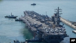 ARCHIVO - El portaaviones estadounidense USS Ronald Reagan es escoltado cuando llega a Busan, Corea del Sur, el 23 de septiembre de 2022.