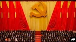 FILE - Chinese President Xi Jinping, front row center, stands with his cadres during the Communist song at the closing ceremony for the 19th Party Congress at the Great Hall of the People in Beijing on Oct. 24, 2017.