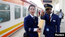 FILE - Kenya Railways attendants talk next to a train along the Standard Gauge Railway (SGR) line constructed by the China Road and Bridge Corporation (CRBC) and financed by Chinese government in Ongata Rongai, Kenya October 16, 2019.