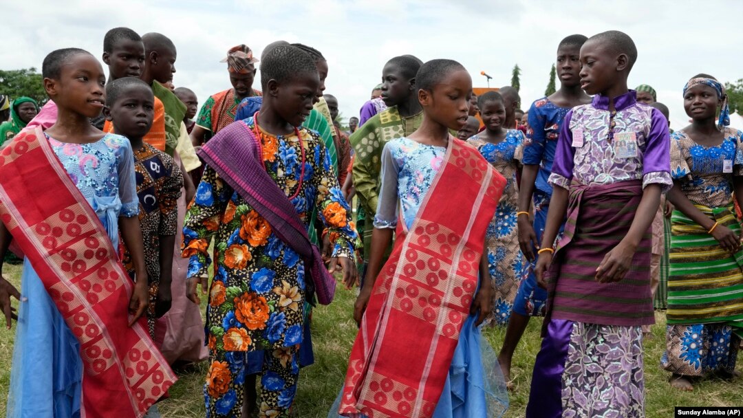 Sejumlah saudara kembar saat festival kembar tahunan di Igbo-Ora Barat daya Nigeria, Sabtu, 8 Oktober 2022. Kota ini mengadakan festival tahunan untuk merayakan tingginya jumlah anak kembar dan banyaknya kelahiran. (Foto: AP/Sunday Alamba)