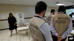 Members of the Electoral Observation Mission of the Organization of American States, OAS, tour a polling station during a presidential run-off election in Brasilia, Brazil, Oct. 30, 2022. 