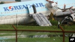A security guard walks beside a damaged Korean Air plane on Oct. 24, 2022 after it overshot the runway at the Mactan-Cebu International Airport in Cebu, central Philippines. 