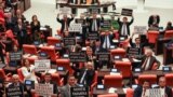 Opposition Republican People's Party deputies hold signs as they protest against a government-backed bill that criminalizes "disinformation," at the Grand National Assembly of Turkey in Ankara, Oct. 4, 2022. 