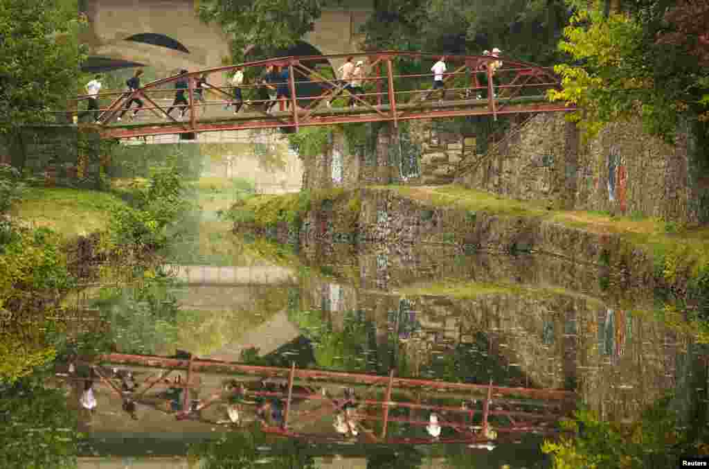 A group of runners cross a bridge over the C&O canal on a misty autumn morning in the Georgetown neighborhood of Washington, Oct. 25, 2022.