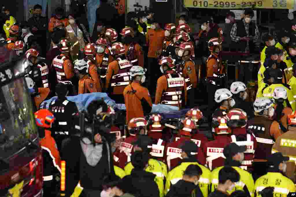 Rescue workers, firefighters and police officers are seen on the street near the scene in Seoul, South Korea, Oct. 30, 2022.