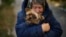 A woman warms her dog in Kivsharivka, Ukraine, Oct. 16, 2022. As temperatures drop in Ukraine, those who haven't fled the Russian occupation are on the threshold of winter. The UNHCR has launched a global campaign to help people displaced by war and persecution survive winter.