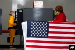 FILE - A voter marks her ballot during the first day of early voting in Atlanta on Oct. 17, 2022.