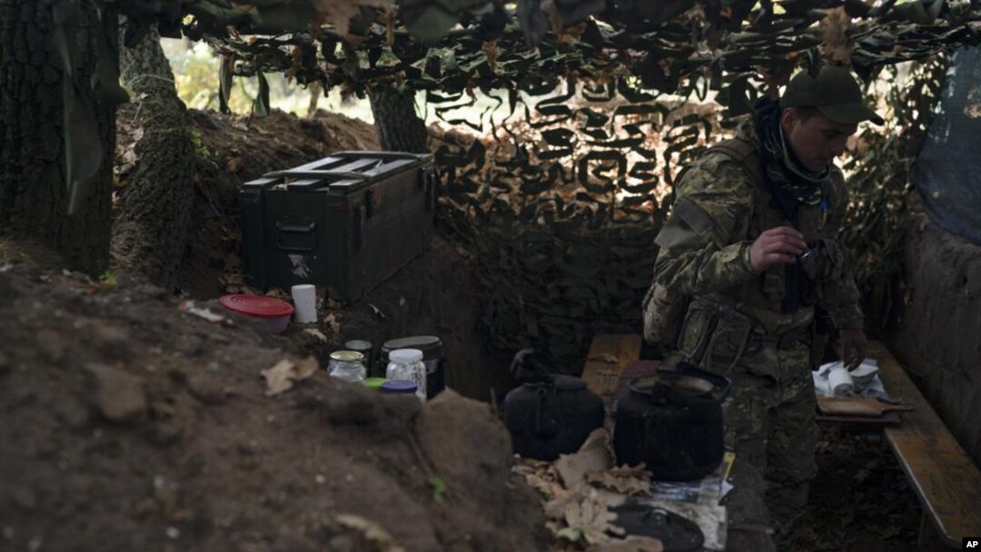 Seorang tentara Ukraina tampak memeriksa parit yang digali oleh tentara Rusia di wilayah Kherson, pada 12 Oktober 2022. (Foto: AP/Leo Correa)
