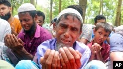 FILE - Rohingya refugees cry while praying during a gathering to mark the fifth anniversary of their exodus from Myanmar to Bangladesh, at a Kutupalong Rohingya refugee camp at Ukhiya in Cox's Bazar district, Bangladesh, Aug. 25, 2022.