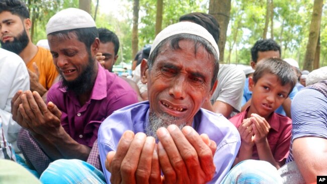 FILE - Rohingya refugees cry while praying during a gathering to mark the fifth anniversary of their exodus from Myanmar to Bangladesh, at a Kutupalong Rohingya refugee camp at Ukhiya in Cox's Bazar district, Bangladesh, Aug. 25, 2022.