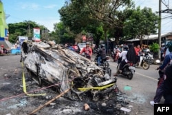 Kendaraan yang dibakar di luar stadion Kanjuruhan di Malang, Jawa Timur pada 2 Oktober 2022. (Foto: AFP)