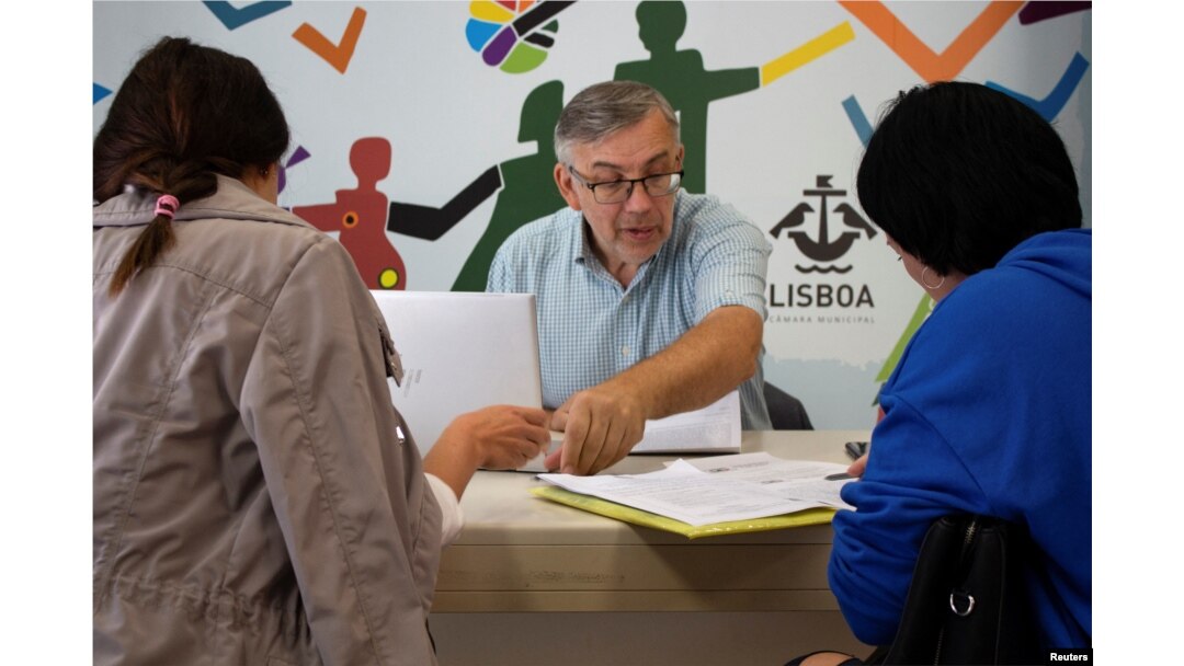 FILE - Ukrainian refugee Ihor Ostrovskyi helps newly arrived Ukrainian refugees at a support center in Lisbon, Portugal, Sept. 27, 2022.