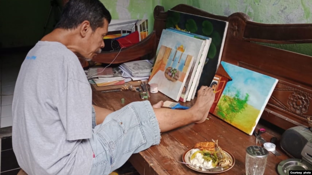 Salim melukis di rumahnya (foto: courtesy). 