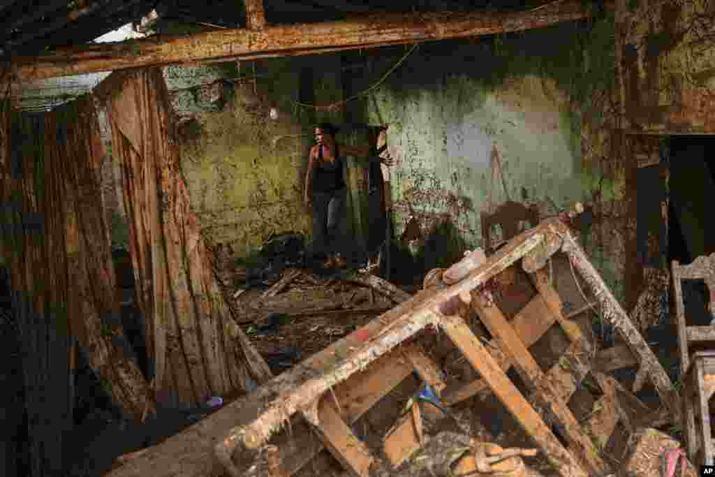 Erika Quintero stands in her home that was damaged after a landslide and flood ripped through Las Tejerias in Venezuela, Oct. 10, 2022. 