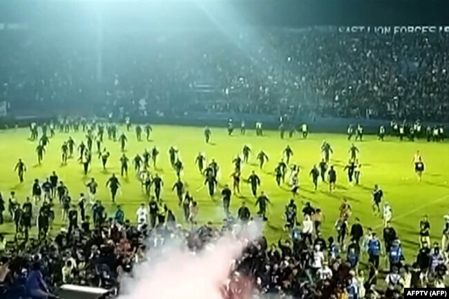 Tangkapan layar video AFPTV yang diambil pada 1 Oktober 2022 menunjukkan gas air mata yang disemprotkan di kerumunan saat suporter berlarian di lapangan setelah pertandingan sepak bola antara Arema FC dan Persebaya Surabaya di Stadion Kanjuruhan di Malang