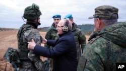 FILE - Russian President Vladimir Putin, center, speaks to a soldier as he visits a military training center of the Western Military District for mobilized reservists in Ryazan region, Russia, Oct. 20, 2022. 