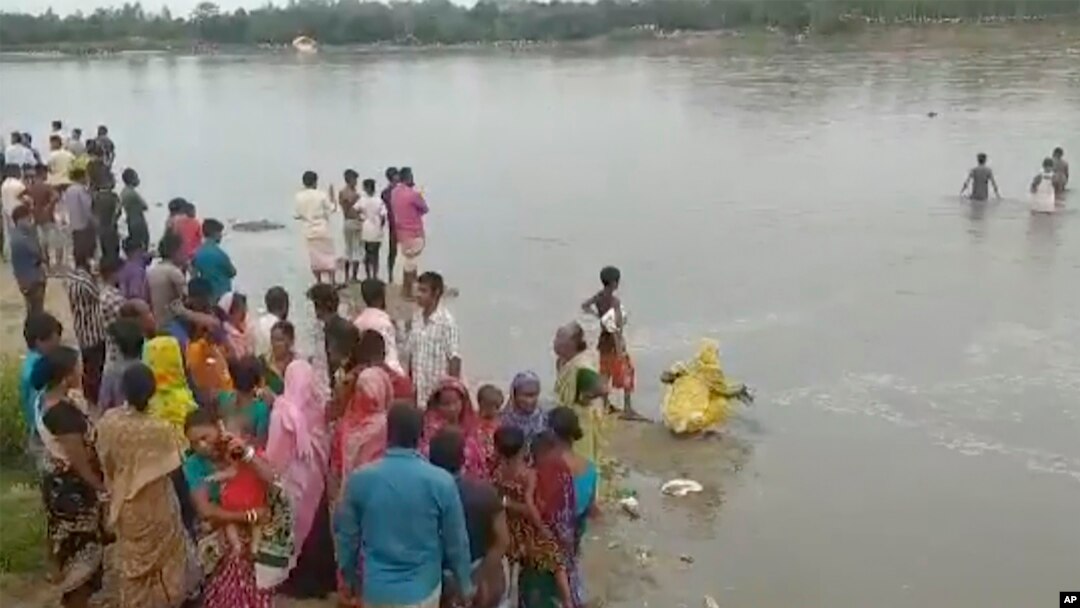 Dalam gambar yang diambil dari video ini, orang-orang mencari korban kapal yang terbalik karena kelebihan muatan di Sungai Karato, Panchagarh, Bangladesh, Minggu, 25 September 2022. (AP)