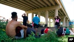 Migrantes esperando a ser procesados por la Patrulla Fronteriza tras cruzar de forma ilegal el Río Bravo desde México y hasta Estados Unidos, en Eagle Pass, Texas, el 26 de agosto de 2022.