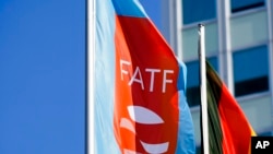 FILE - A flag with the logo of the Financial Action Task Force waves in the wind during a meeting of the task force at the Congress Center in Berlin, Germany, June 17, 2022.