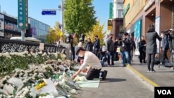 Maeng Geun-yeong, yang bekerja sebagai petugas keamanan di Itaewon, menaruh bunga di area peringatan bagi para korban tewas dalam tragedi desak-desakan di Itaewon, pada 31 Oktober 2022. (Foto: VOA/Lee Juhyun)