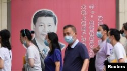 上海民众走过街头树立的一面中国领导人习近平的宣传画。（2022年8月31日）
