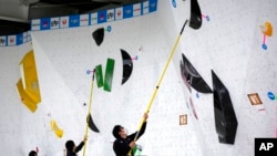 Staff clean the wall stones during the women's and men's boulder semi-final of IFSC Climbing World Cup, Oct. 21, 2022, in Morioka, Iwate Prefecture, Japan.