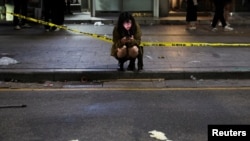 Žena koristi telefon u blizini mjesta gdje je mnogo ljudi umrlo i ozlijeđeno u stampedu tijekom festivala za Noć vještica u Seulu, Južna Koreja, 30. oktobra 2022.