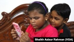Two elementary school students engrossed in a mobile phone, 11 Oct, 2022. School children used mobile phones to study online during the COVID lockdowns in India and many of them have now turned into what many call 'mobile addicts'.