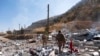 Members of exiled Komala Party inspect aftermath of bombing in the village of Zrgoiz, near Sulaimaniyah, Iraq, where the bases of several Iranian opposition groups are located, Sept. 28, 2022. 