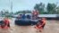 In this photo provided by the Philippine Coast Guard, rescuers use boats to evacuate residents from flooded areas due to Tropical Storm Nalgae at Parang, Maguindanao province, southern Philippines, Oct. 28, 2022.