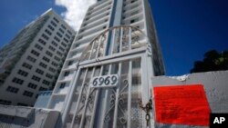 An unsafe building notice marks the chained off beach entrance to the Port Royale building in Miami Beach, Fla., after it was ordered evacuated Thursday due to concerns over its structural safety, Oct. 28, 2022.