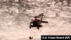 In this screenshot from video, the U.S. Coast Guard rescues boaters off the coast of Empire, La., on Oct. 9, 2022.