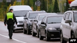 A border guard officer controls the vehicles entering Finland at the border checkpoint crossing in Vaalimaa, Finland, on the border with the Russian Federation on Sept. 29, 2022.