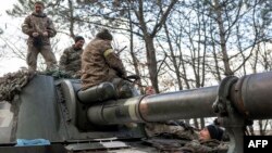 Ukrainian artillery unit members get prepared to fire towards Kherson on Oct. 28, 2022, outside of Kherson region, amid Russia's military invasion on Ukraine.