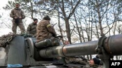 Ukrainian artillery unit members get prepared to fire towards Kherson on Oct. 28, 2022, outside of Kherson region, amid Russia's military invasion on Ukraine.
