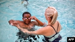 Swim Up DC co-founder Mary Bergstrom holds a free swimming lesson with students of Bishop John T. Walker School for Boys at Ferebee-Hope Aquatic Center in Washington, Oct. 12, 2022.